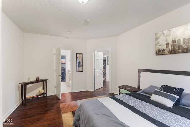 bedroom with a textured ceiling and dark wood-type flooring