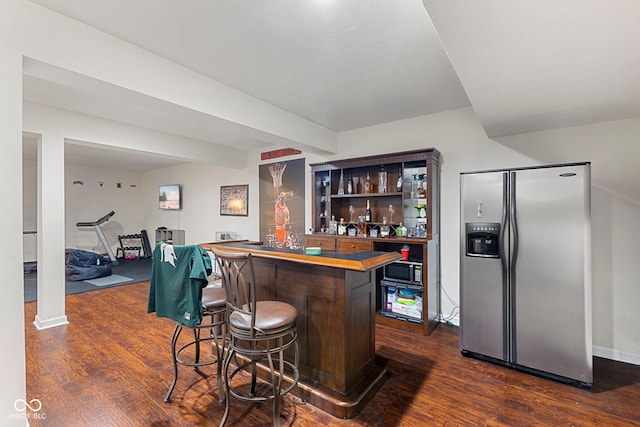 bar featuring appliances with stainless steel finishes, dark hardwood / wood-style floors, and butcher block counters