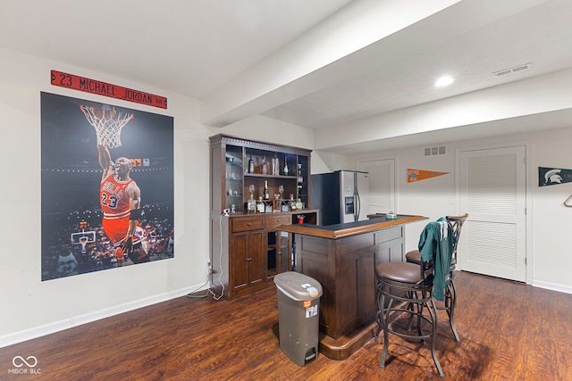 bar featuring stainless steel fridge and dark hardwood / wood-style flooring