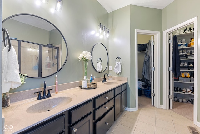 bathroom with tile patterned flooring, vanity, and a shower with door