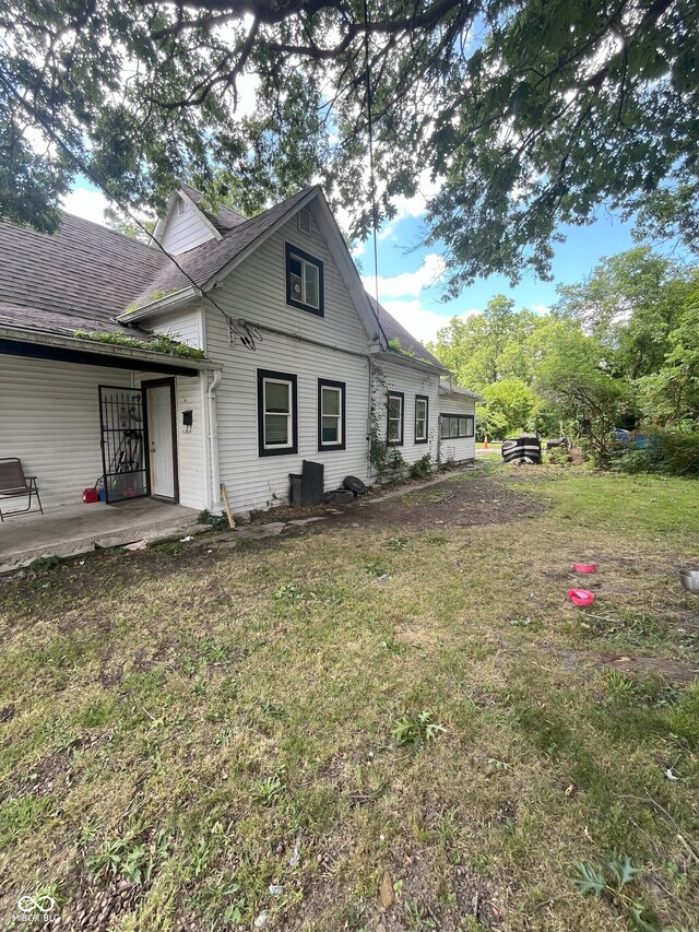 back of property featuring a lawn and a patio