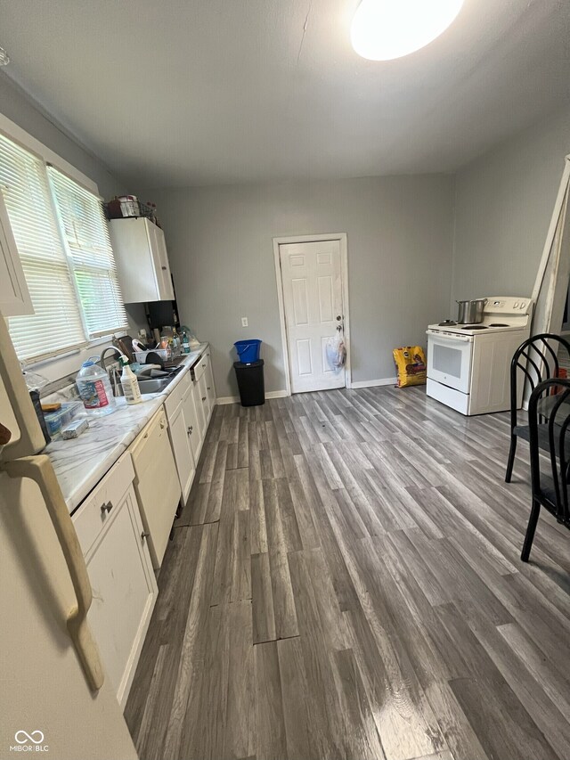 kitchen featuring electric range, sink, white cabinets, and dark wood-type flooring