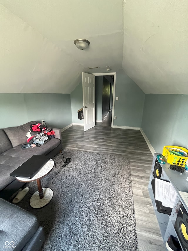 additional living space with hardwood / wood-style flooring and vaulted ceiling