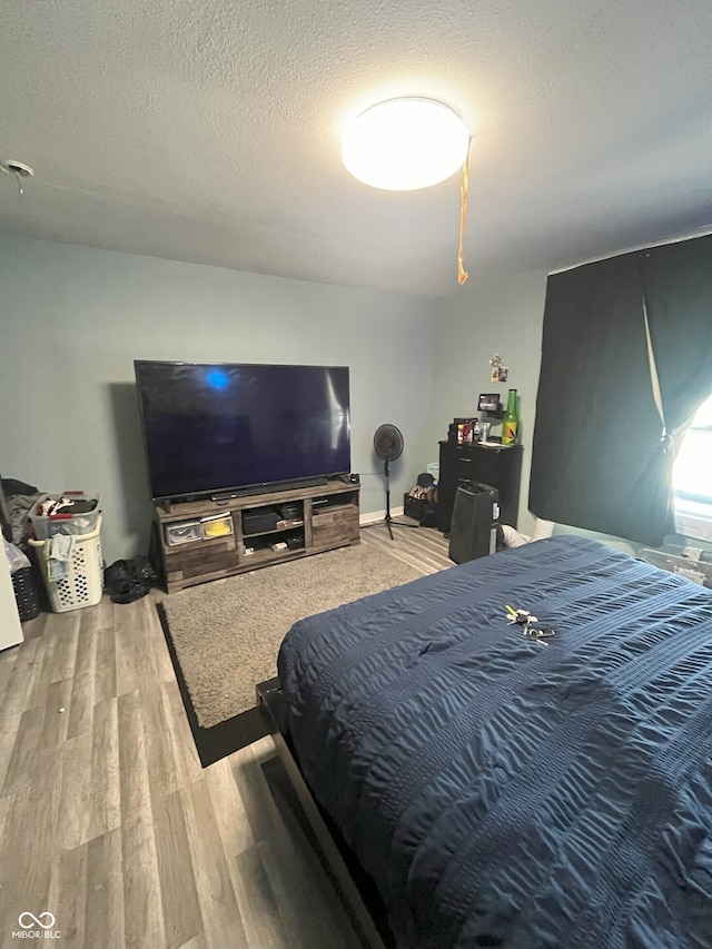 bedroom with a textured ceiling and hardwood / wood-style flooring