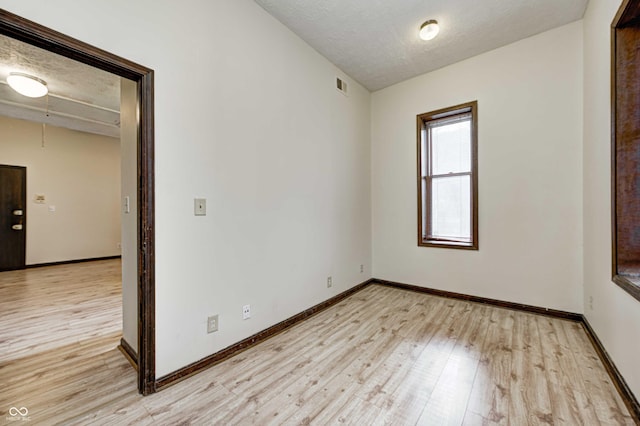 unfurnished room featuring a textured ceiling and light hardwood / wood-style floors