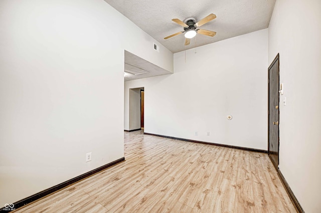 unfurnished room with a textured ceiling, light hardwood / wood-style floors, and ceiling fan