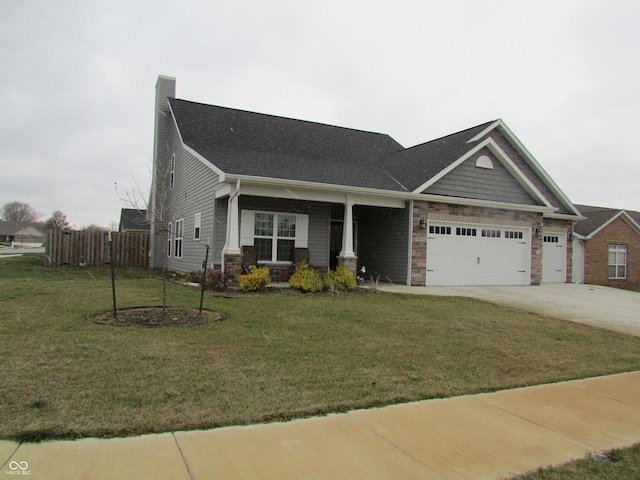 craftsman inspired home featuring a garage and a front lawn