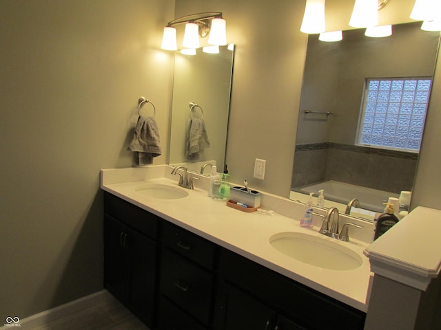 full bath with baseboards, a sink, a bath, and double vanity