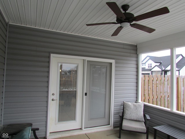 property entrance with fence and a ceiling fan