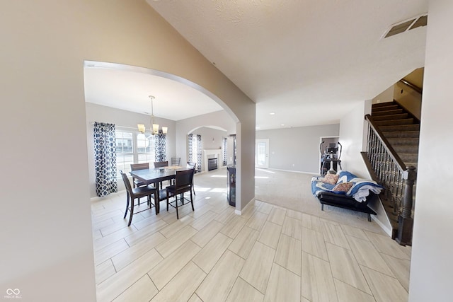 dining area with baseboards, stairs, visible vents, and a notable chandelier