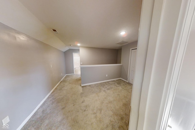 below grade area with visible vents, baseboards, and light colored carpet