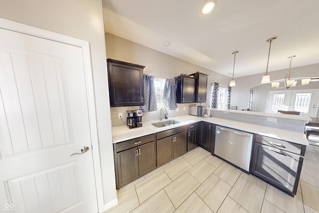 kitchen featuring dark brown cabinetry, a sink, light countertops, dishwasher, and tasteful backsplash