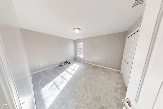 unfurnished bedroom featuring baseboards, visible vents, and light colored carpet