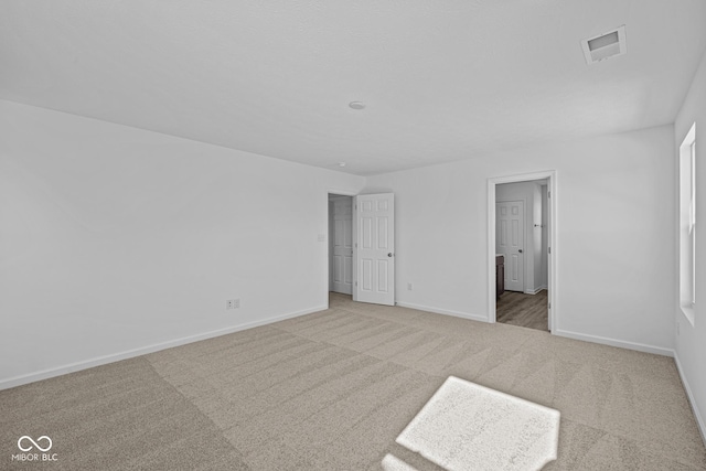 unfurnished bedroom featuring ensuite bath and carpet flooring