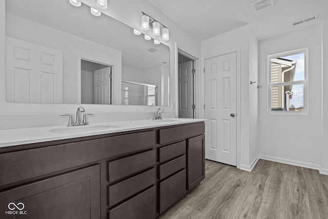 bathroom featuring vanity, an enclosed shower, and hardwood / wood-style flooring