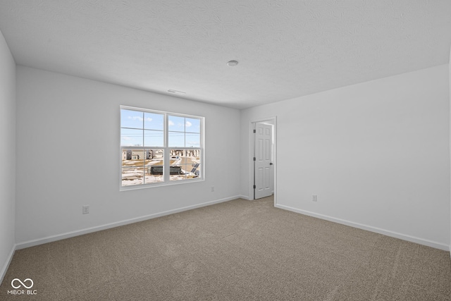 carpeted spare room with a textured ceiling