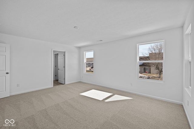 carpeted spare room featuring a textured ceiling