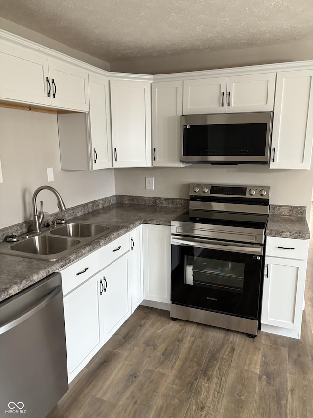 kitchen with sink, white cabinets, stainless steel appliances, and dark hardwood / wood-style floors