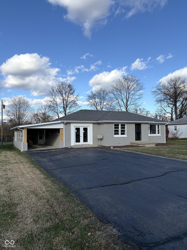 ranch-style home featuring a front yard and a carport