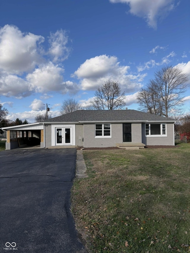 ranch-style home featuring a carport, a front yard, and french doors