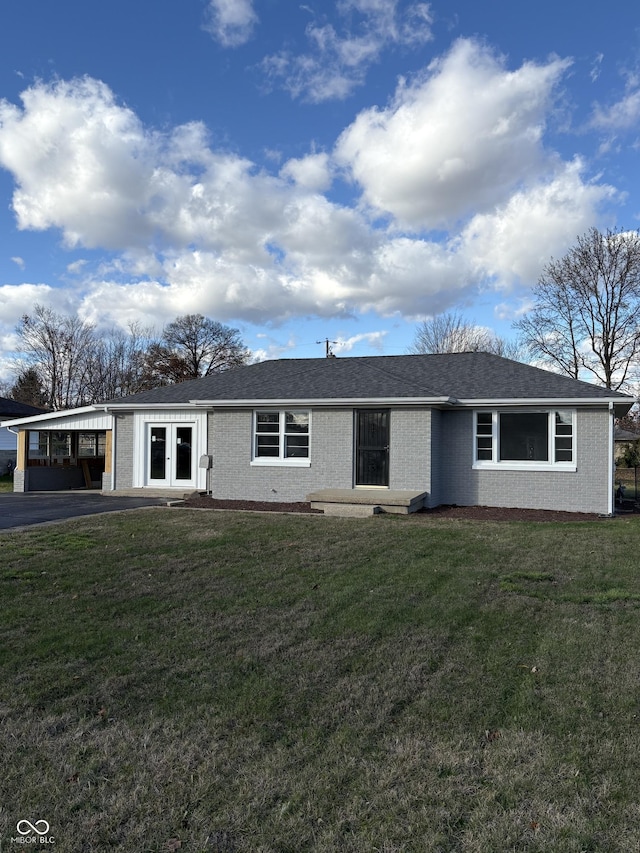 ranch-style house featuring a front yard and a carport