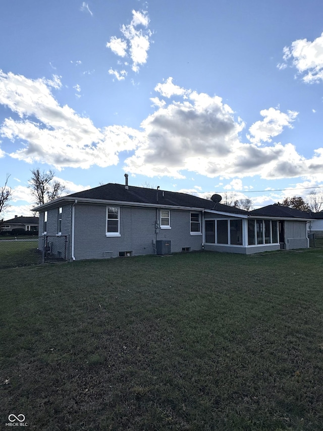 back of property featuring a yard, a sunroom, and central air condition unit