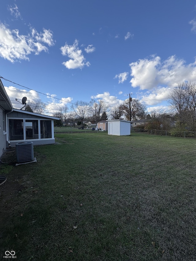 view of yard with central AC unit and a shed