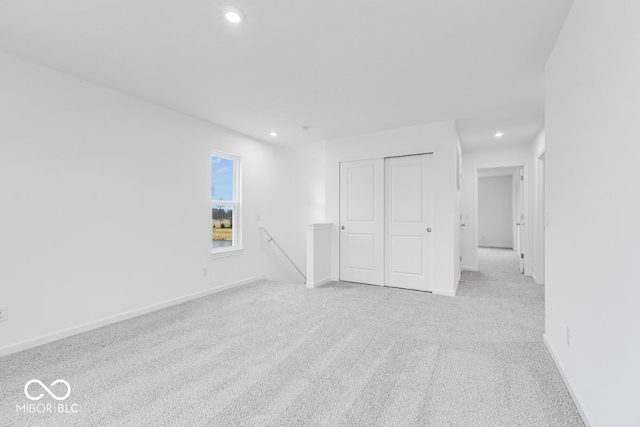 empty room with recessed lighting, light colored carpet, and baseboards