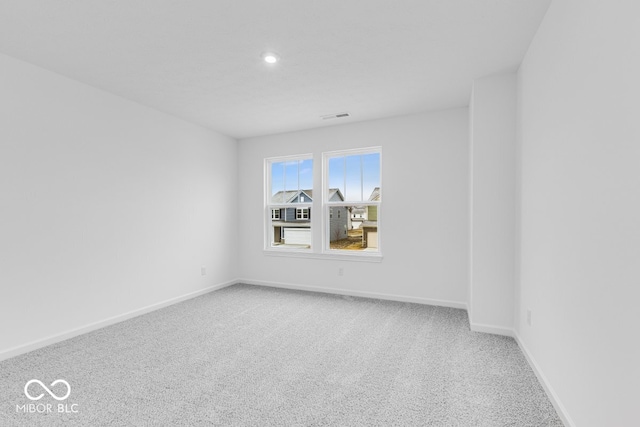 empty room featuring carpet, visible vents, baseboards, and recessed lighting