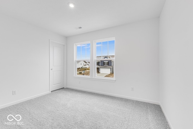 empty room featuring carpet floors, visible vents, and baseboards