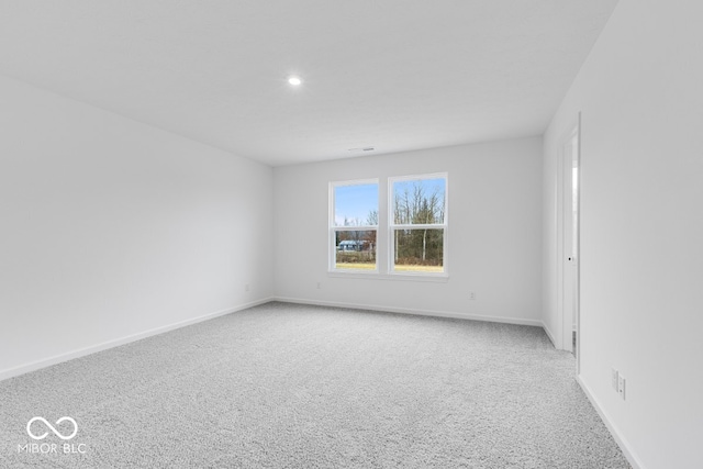 empty room featuring light carpet, recessed lighting, and baseboards