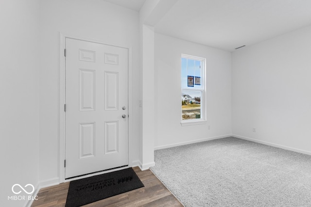 foyer featuring dark wood finished floors, visible vents, and baseboards