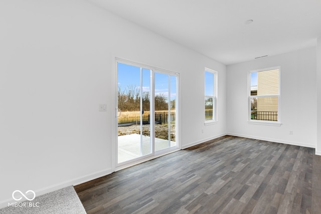 empty room featuring dark wood-style floors and baseboards