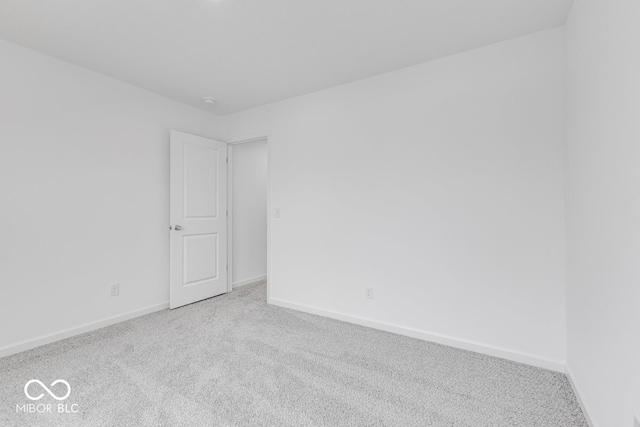 spare room with light carpet and baseboards