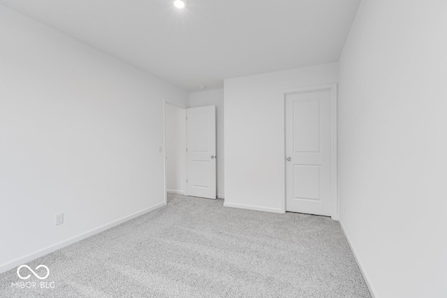 unfurnished bedroom with baseboards and light colored carpet