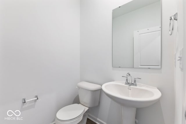 bathroom featuring a sink, toilet, and baseboards