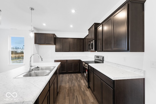 kitchen with dark wood finished floors, recessed lighting, hanging light fixtures, appliances with stainless steel finishes, and a sink