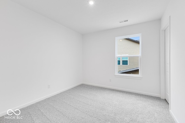 unfurnished room featuring carpet floors, visible vents, and baseboards