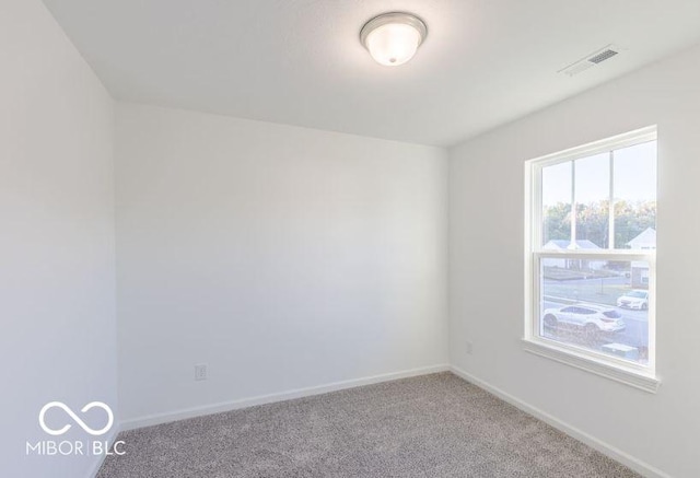 carpeted empty room with visible vents and baseboards