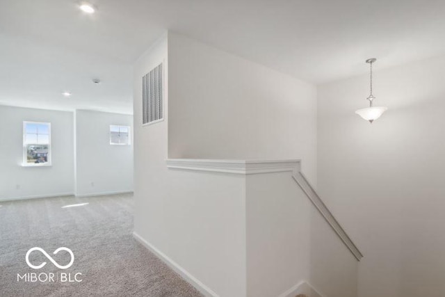 hall with visible vents, baseboards, carpet, an upstairs landing, and recessed lighting