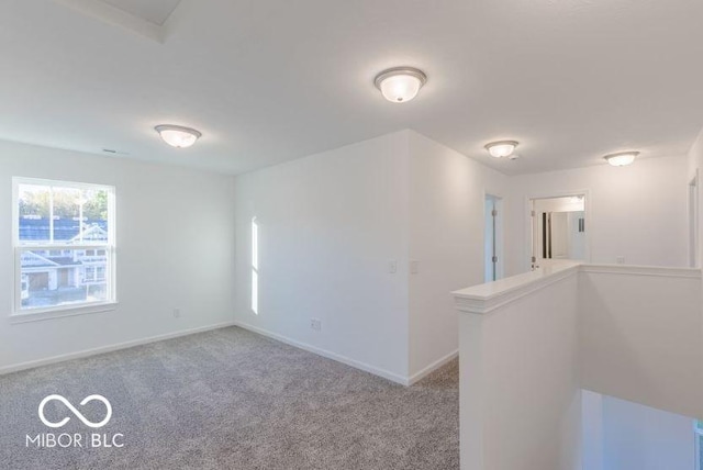 spare room with light carpet and baseboards