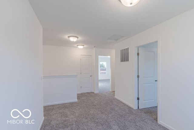 unfurnished room featuring light carpet, baseboards, and visible vents