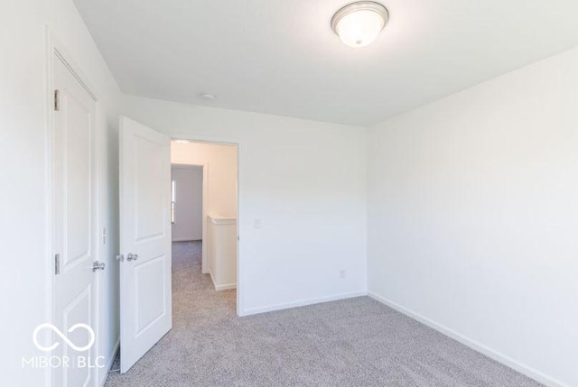 interior space featuring light carpet and baseboards