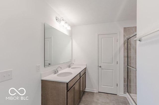 bathroom featuring double vanity, a shower stall, and a sink