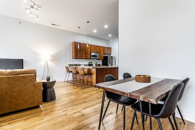 dining room featuring track lighting and light hardwood / wood-style flooring