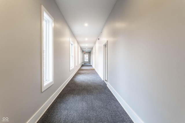 corridor featuring dark carpet