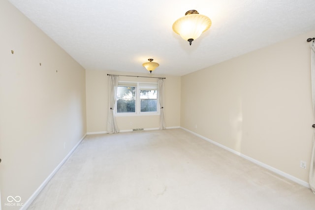 carpeted empty room with a textured ceiling