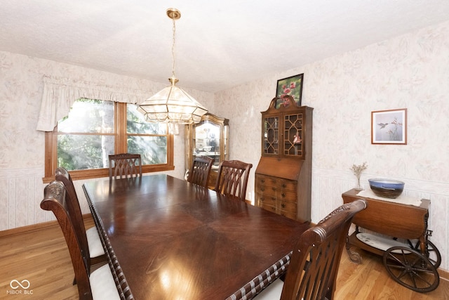 dining space featuring hardwood / wood-style floors and an inviting chandelier