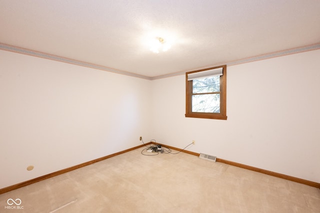 carpeted spare room with a textured ceiling and ornamental molding