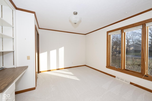 spare room featuring crown molding and light carpet